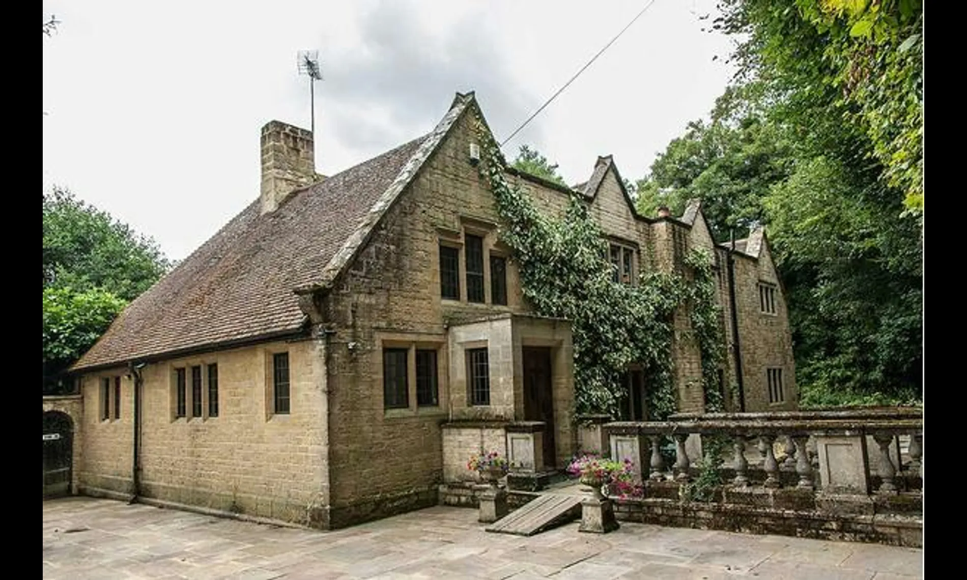 The ivy-grown stone facade and terrace steps at Netley Mill House